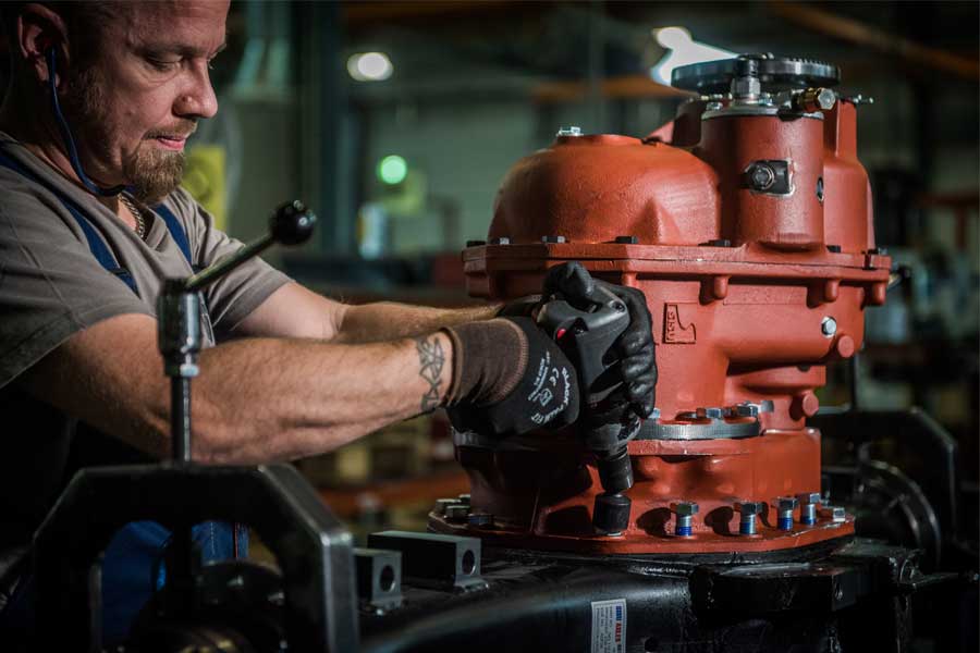 Male mechanical worker working on axle alignment