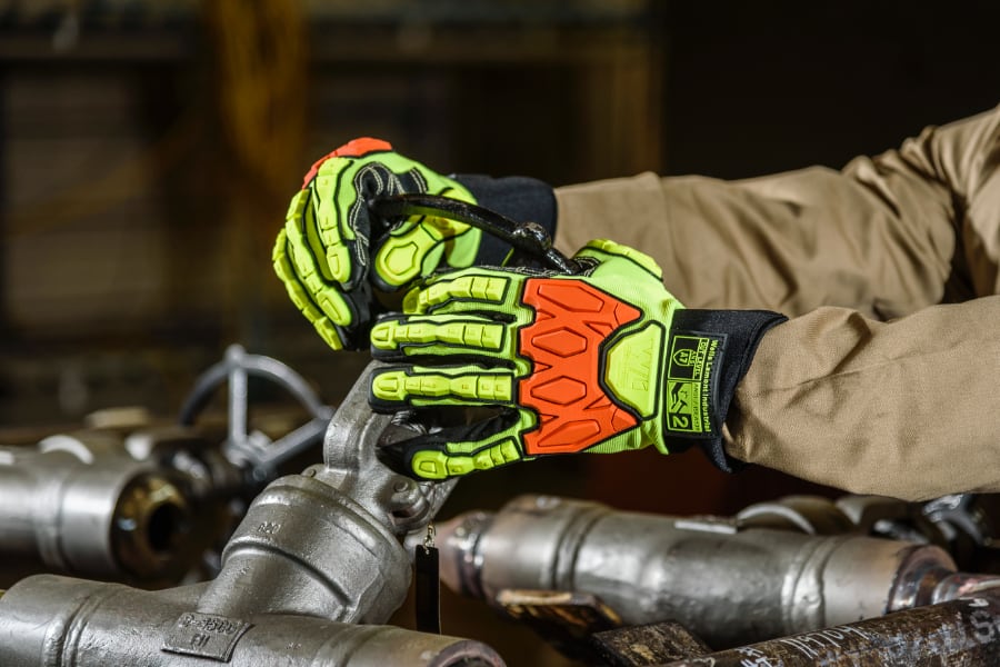 Industrial employee wearing protective gloves and working with metals