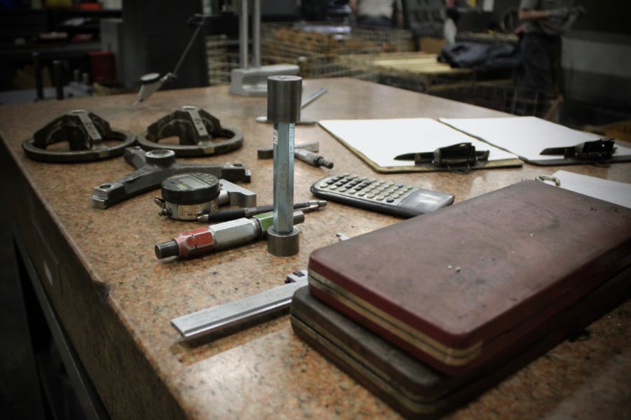 Tools, calculator, and clipboard sitting on a workbench