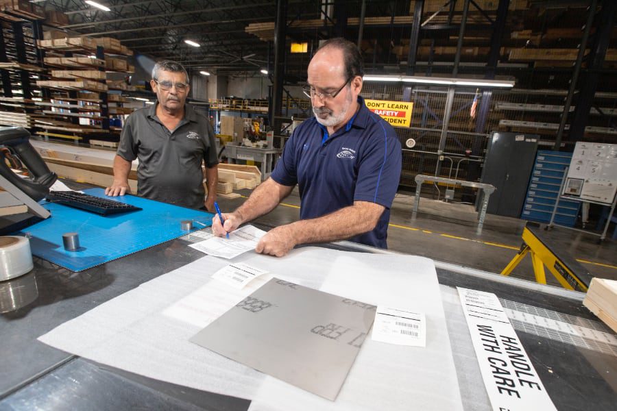 Industrial warehouse workers working on plans and signing off on plans.