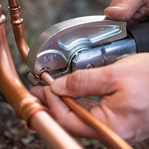 Close up of hand using RLS product on copper tubing