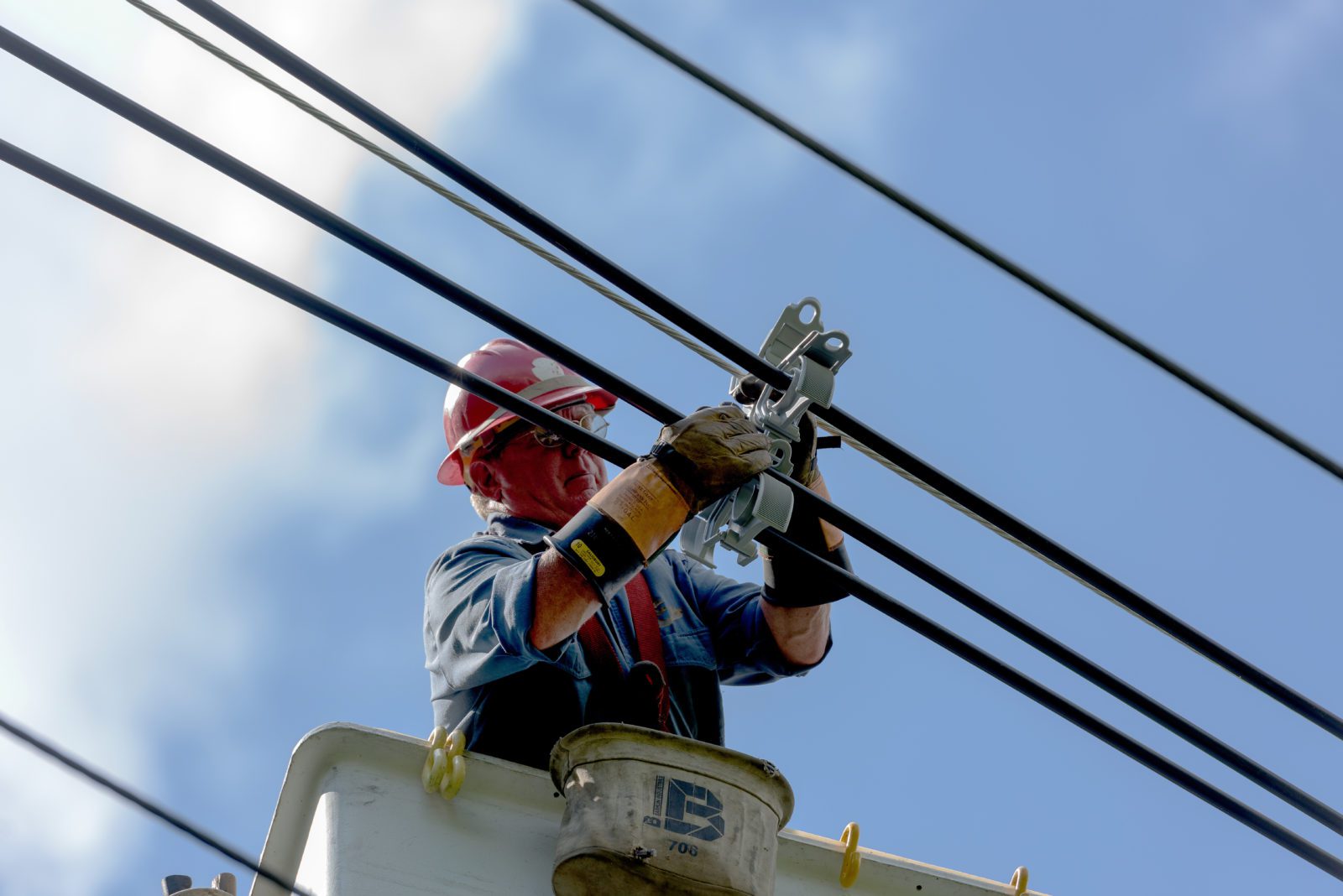 utility worker hanging electrical lines