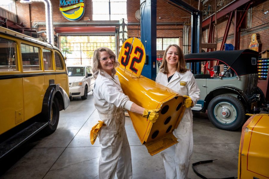 Two Marmon Wasp engineers holding a part of the Marmon Wasp Replica car.