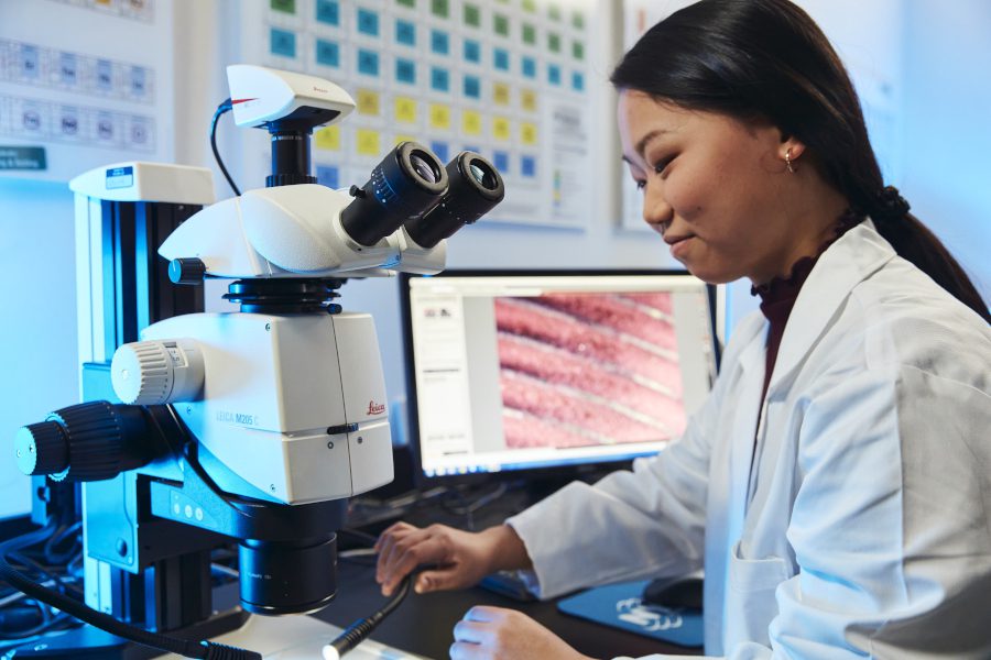 Marmon scientist working at a microscope and computer